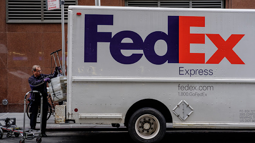 A person loading shipment in a Fedex branded van