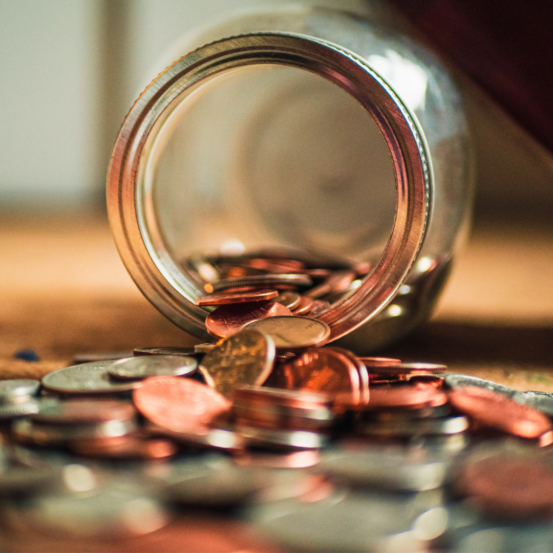 coins pouring out from a glass jar