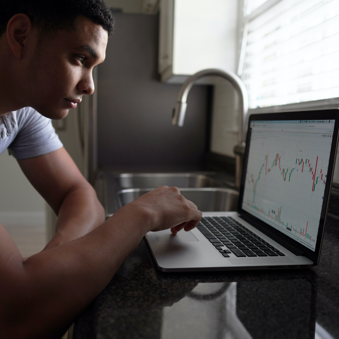 man working on laptop, looking at a graph