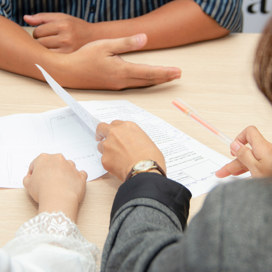 people discussing with papers lying on the table